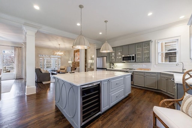 kitchen with wine cooler, glass insert cabinets, appliances with stainless steel finishes, gray cabinets, and ornate columns