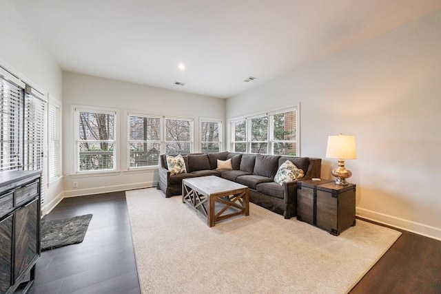 living area featuring visible vents, baseboards, and dark wood-style flooring