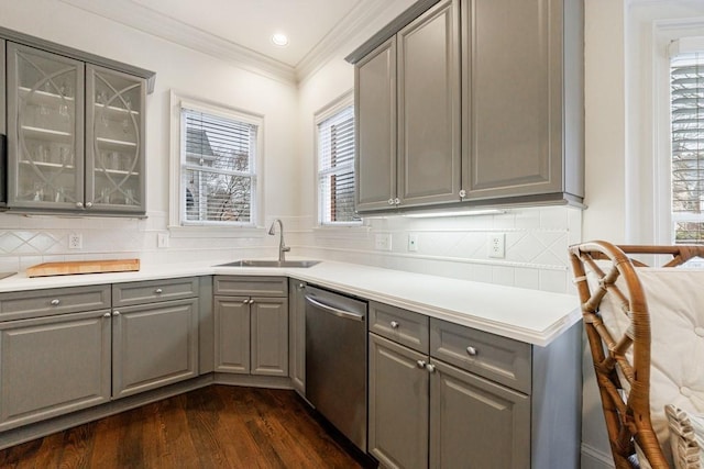 kitchen with decorative backsplash, dishwasher, glass insert cabinets, gray cabinets, and a sink