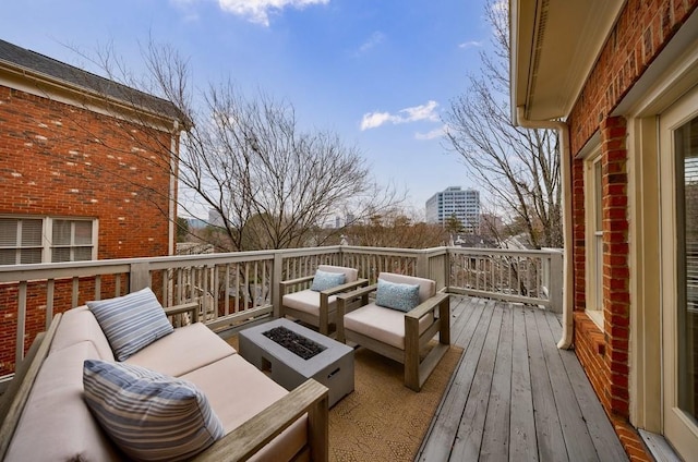 wooden terrace with an outdoor living space with a fire pit