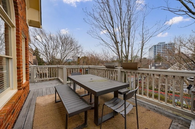 view of wooden balcony featuring outdoor dining area and a wooden deck