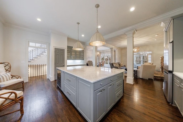 kitchen featuring dark wood-style floors, open floor plan, gray cabinets, ornate columns, and a chandelier