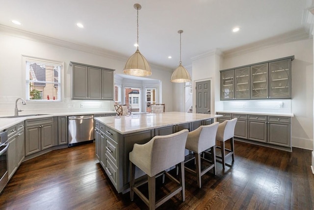 kitchen featuring dishwasher, dark wood-style floors, a center island, gray cabinets, and a sink