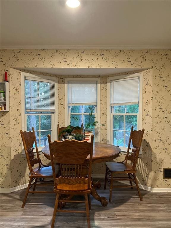 1017 Clifton Dr, Macon, GA 31204 - dining area with crown molding, wallpapered walls, wood finished floors, baseboards, and healthy amount of natural light