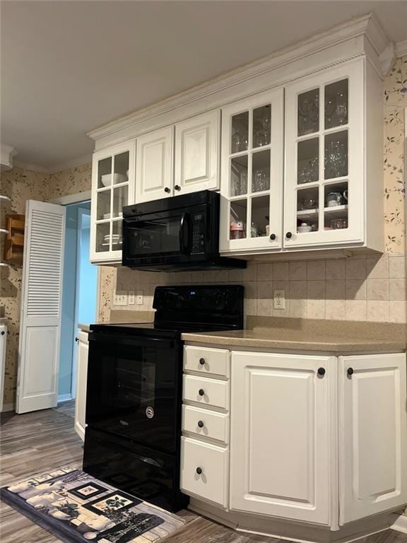 1017 Clifton Dr, Macon, GA 31204 - kitchen featuring black appliances, wallpapered walls, white cabinets, wood finished floors, and glass insert cabinets