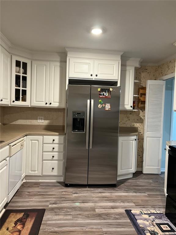 1017 Clifton Dr, Macon, GA 31204 - kitchen with stainless steel fridge with ice dispenser, white dishwasher, white cabinets, glass insert cabinets, and wood finished floors