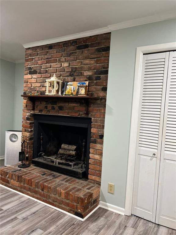 1017 Clifton Dr, Macon, GA 31204 - detailed view of crown molding, wood finished floors, baseboards, and a brick fireplace