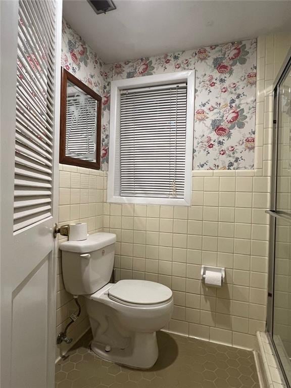 1017 Clifton Dr, Macon, GA 31204 - bathroom with wallpapered walls, tile patterned flooring, toilet, a stall shower, and wainscoting