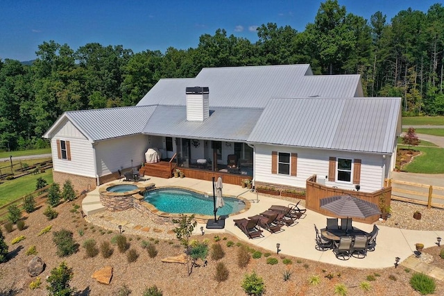 back of house featuring an in ground hot tub and a patio area