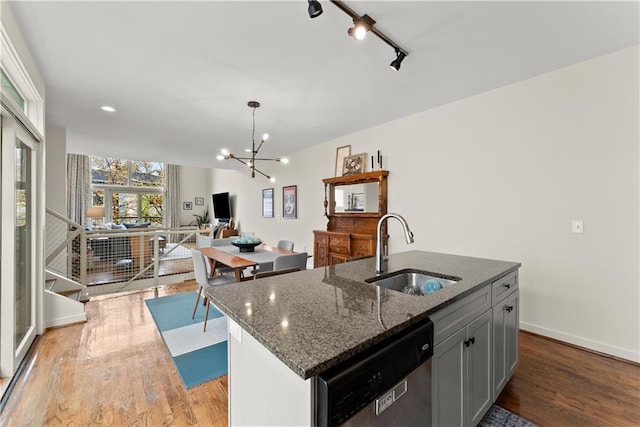 1382 Stirling Cir NW, Atlanta, GA 30318 - kitchen featuring dark stone countertops, a sink, dishwasher, a notable chandelier, and wood finished floors