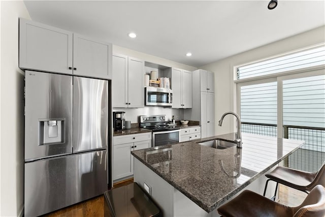 1382 Stirling Cir NW, Atlanta, GA 30318 - kitchen with a sink, a breakfast bar area, a center island with sink, stainless steel appliances, and recessed lighting