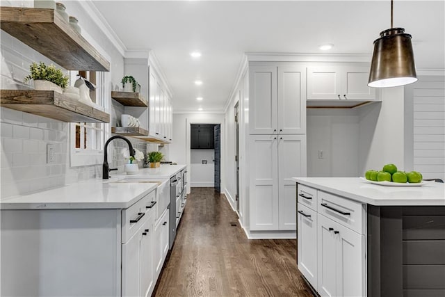 kitchen featuring pendant lighting, dark hardwood / wood-style floors, white cabinets, decorative backsplash, and ornamental molding