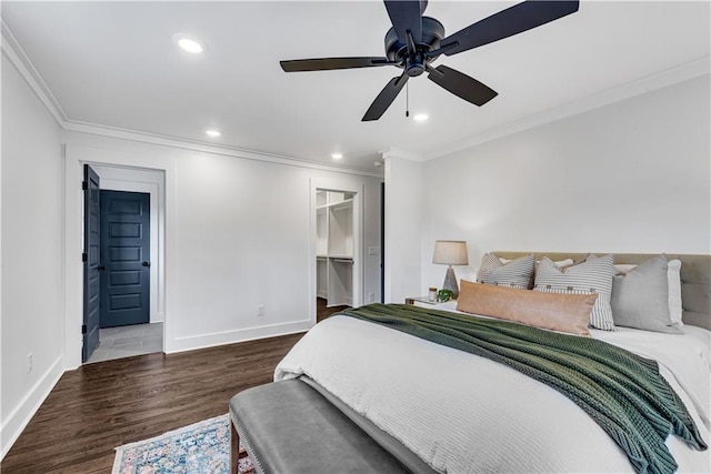 bedroom featuring a spacious closet, dark hardwood / wood-style flooring, a closet, ceiling fan, and ornamental molding