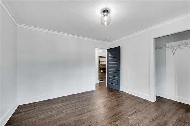 unfurnished bedroom with ornamental molding, dark hardwood / wood-style floors, and a closet