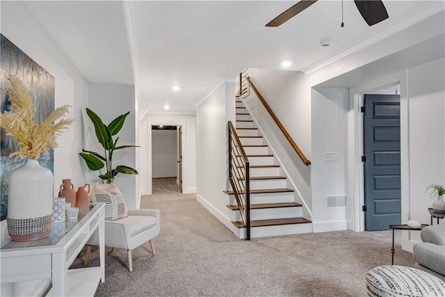 interior space featuring ceiling fan, ornamental molding, and carpet