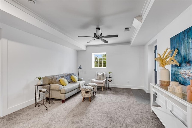 living area featuring carpet, crown molding, and ceiling fan