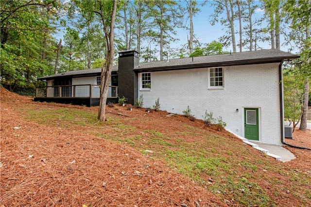 rear view of property with central AC