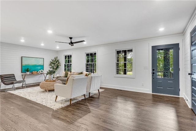 living room with crown molding, dark hardwood / wood-style floors, and ceiling fan