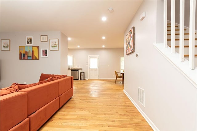 living room featuring visible vents, stairs, baseboards, light wood-type flooring, and recessed lighting