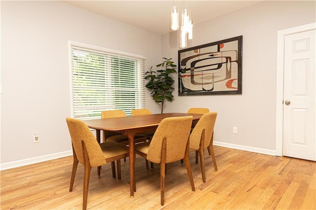 dining room with baseboards and light wood-type flooring