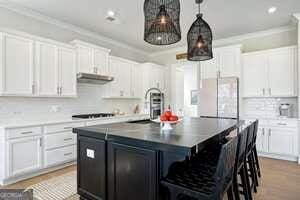 247 Widener Way, Peachtree City, GA 30269 - kitchen featuring under cabinet range hood, double oven, white cabinets, gas stovetop, and crown molding