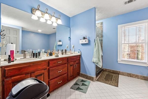 bathroom featuring tile patterned flooring, vanity, and an enclosed shower