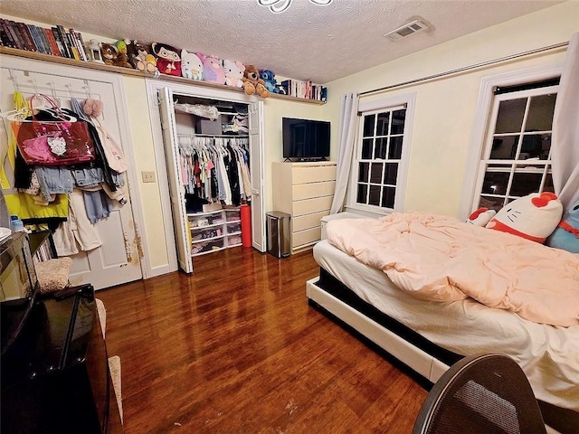 bedroom featuring dark wood-type flooring, a closet, and a textured ceiling