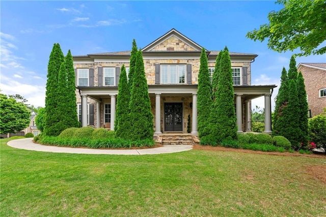 view of front of property featuring a front lawn and stone siding