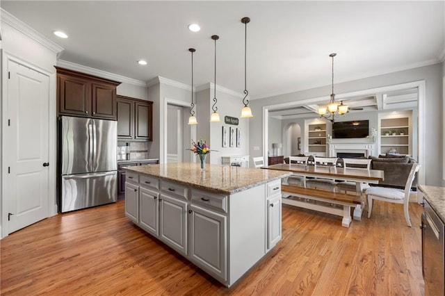 kitchen with stainless steel fridge, light wood-style floors, crown molding, and a kitchen island