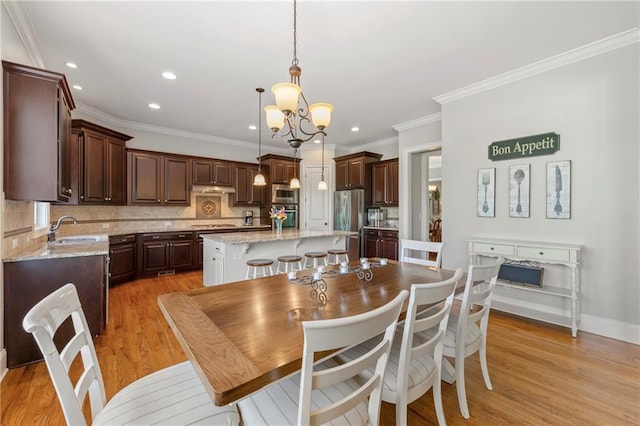 dining room with crown molding, light wood-style floors, baseboards, recessed lighting, and a chandelier