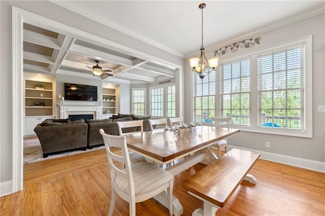 dining area with ornamental molding, a fireplace, baseboards, light wood-type flooring, and coffered ceiling