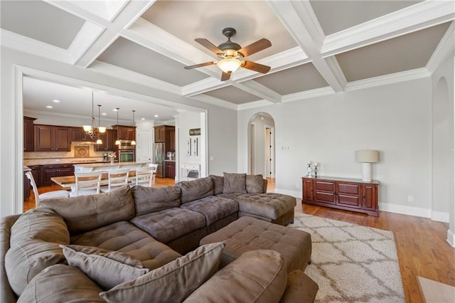 living area featuring arched walkways, baseboards, beam ceiling, and coffered ceiling