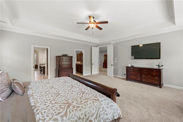 bedroom with carpet flooring, a ceiling fan, baseboards, a tray ceiling, and ornamental molding