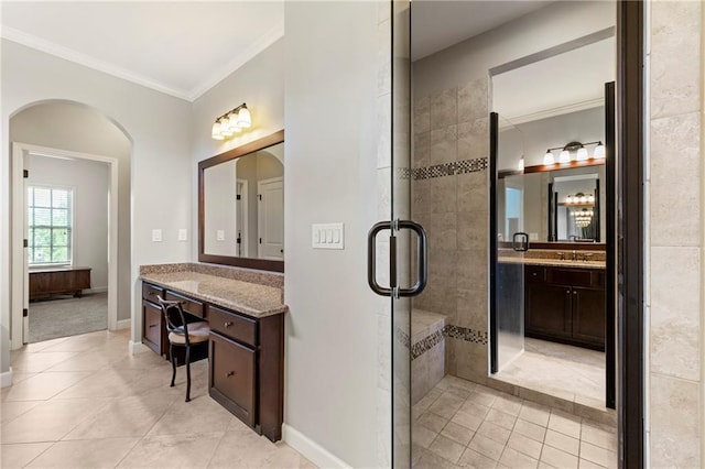 full bath featuring crown molding, vanity, tile patterned floors, baseboards, and tiled shower