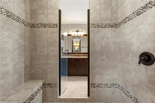 bathroom featuring vanity, ornamental molding, and a tile shower