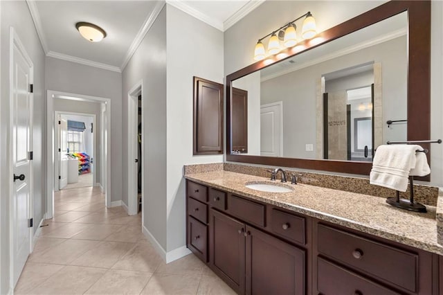 bathroom featuring crown molding, baseboards, tile patterned flooring, and vanity