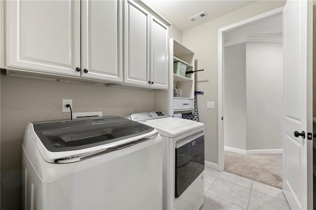 laundry area featuring washer and dryer, light tile patterned flooring, cabinet space, light colored carpet, and visible vents