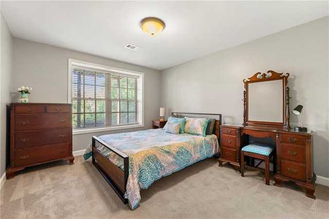 bedroom with visible vents, baseboards, and light carpet