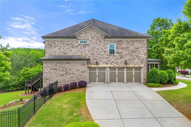 view of side of property with a garage, fence, brick siding, concrete driveway, and a lawn