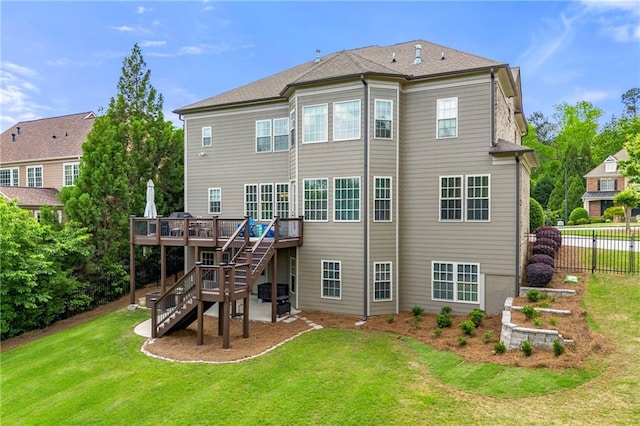back of property with stairway, a deck, fence, and a lawn