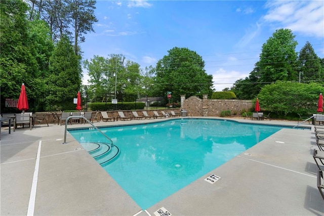 pool featuring fence and a patio