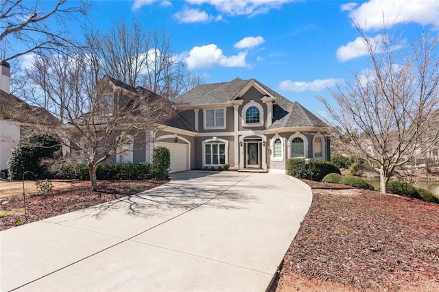 view of front facade with stucco siding, an attached garage, and driveway