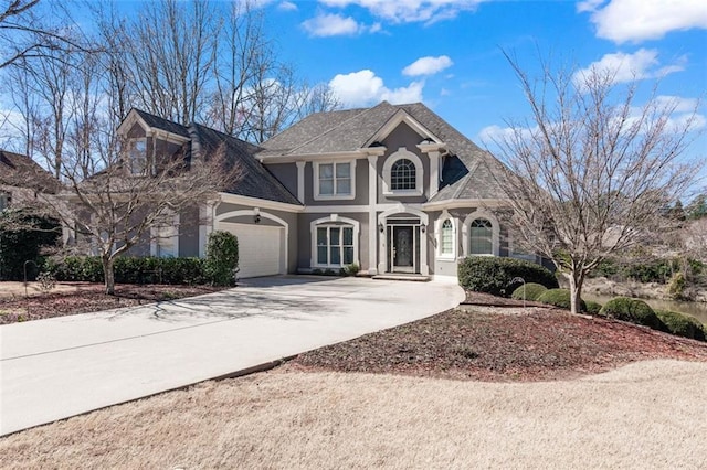 view of front facade featuring stucco siding, concrete driveway, and a garage