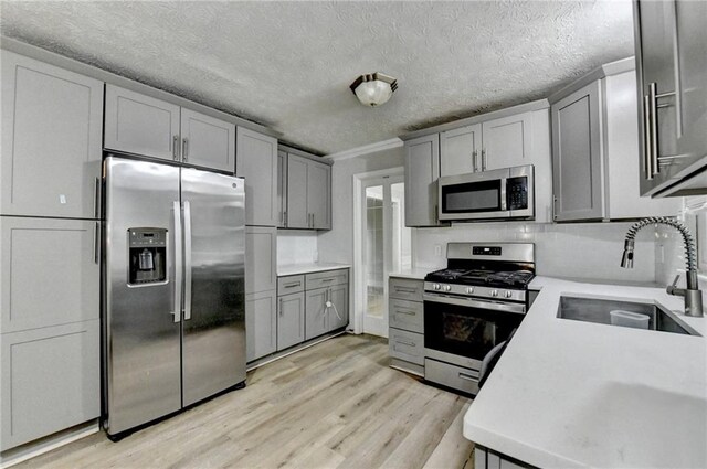 4444 Lisa Way NW, Lilburn, GA 30047 - kitchen with appliances with stainless steel finishes, gray cabinetry, light wood finished floors, light countertops, and a textured ceiling