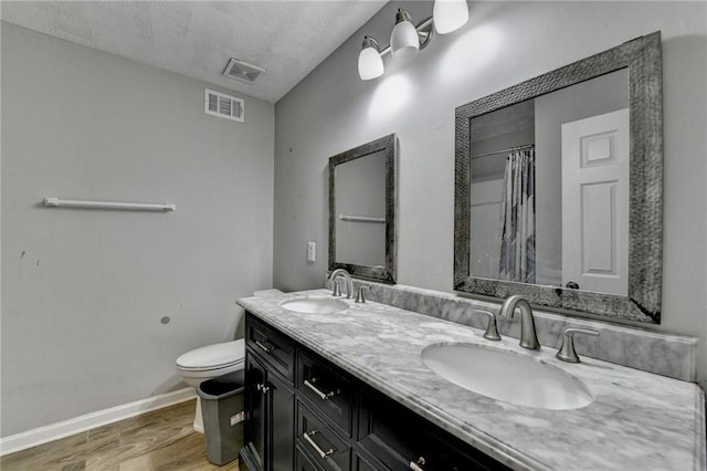4444 Lisa Way NW, Lilburn, GA 30047 - bathroom with wood finished floors, double vanity, a textured ceiling, and a shower with shower curtain