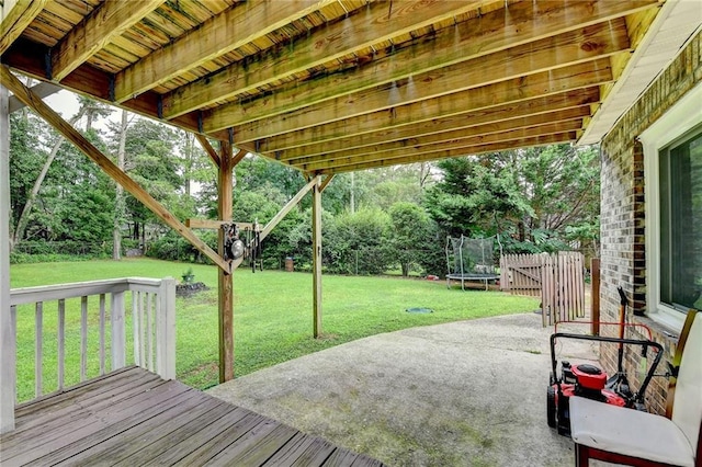 4444 Lisa Way NW, Lilburn, GA 30047 - fenced backyard featuring a trampoline, a patio, a deck, and view of scattered trees
