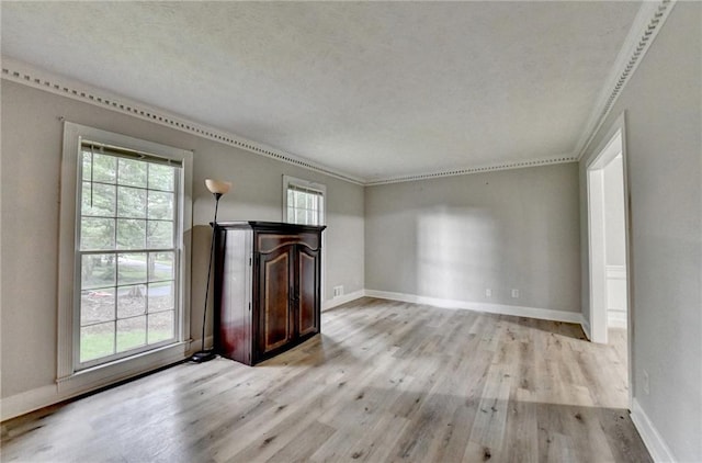 4444 Lisa Way NW, Lilburn, GA 30047 - unfurnished living room featuring crown molding, healthy amount of natural light, light wood-type flooring, and a textured ceiling