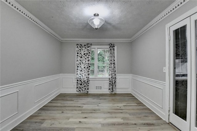 4444 Lisa Way NW, Lilburn, GA 30047 - spare room with a textured ceiling, a wainscoted wall, crown molding, wood finished floors, and a decorative wall