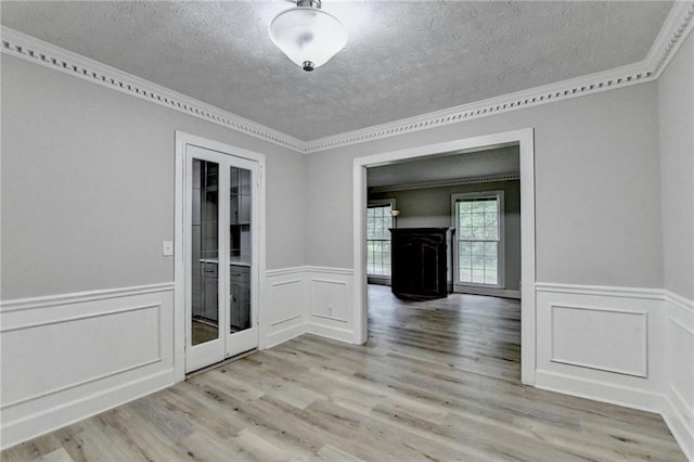 4444 Lisa Way NW, Lilburn, GA 30047 - empty room with a textured ceiling, ornamental molding, wainscoting, wood finished floors, and a decorative wall