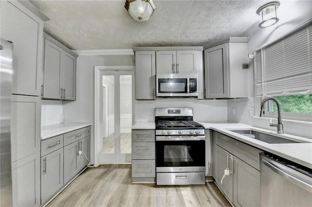 4444 Lisa Way NW, Lilburn, GA 30047 - kitchen featuring stainless steel appliances, gray cabinetry, light wood-style floors, light countertops, and a textured ceiling
